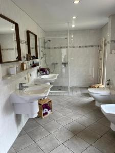 a bathroom with three sinks and a shower at Ferienwohnung Göttert – Haus Erika in Beckingen