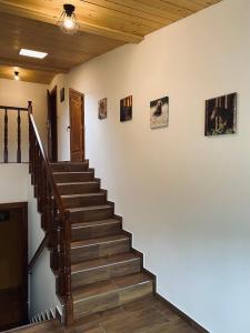 un escalier dans une maison avec des photos sur le mur dans l'établissement Agroturystyka SKALNE, à Szczawa