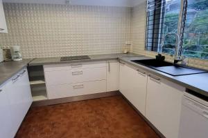 a kitchen with white cabinets and a sink and a window at Appartement magnifique vue mer in Le Gosier