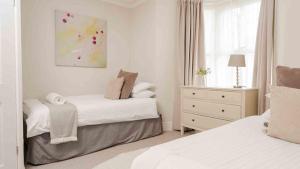 1 dormitorio blanco con 2 camas y ventana en Buxton Lodge en Buxton