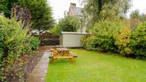 una mesa de picnic y un banco en un jardín en Buxton Lodge en Buxton