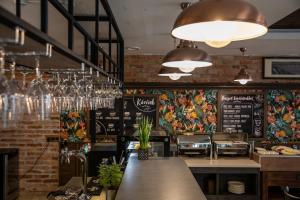 a restaurant with a bar with a brick wall at City Hotel Miskolc in Miskolc +29 photos
