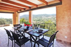 una sala da pranzo con tavolo e sedie sul balcone di Villa Ses Costes by Slow Villas ad Alaró