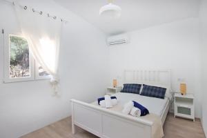 una camera bianca con un letto e una finestra di Villa Ses Costes by Slow Villas ad Alaró
