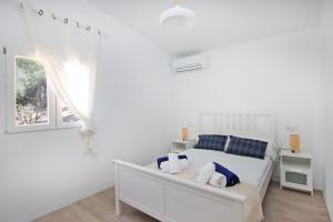 Habitación blanca con cama y ventana en Villa Ses Costes by Slow Villas, en Alaró