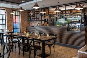 a dining room with tables and chairs and a bar at City Hotel Miskolc in Miskolc