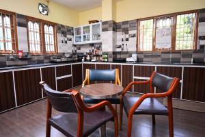 a kitchen with a table and two chairs and a counter at The Hook BnB, Port Blair in Haddo