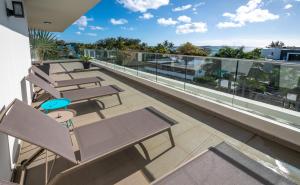 格兰贝伊PENTHOUSE VUE MER - MONT CHOISY的建筑物阳台上的一排长椅 更多42张照片