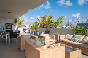 格兰贝伊PENTHOUSE VUE MER - MONT CHOISY的带沙发和桌椅的天井。