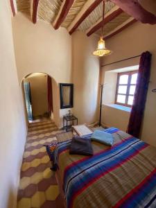 1 dormitorio con 1 cama grande en una habitación en Auberge Famille Benmoro, en Skoura