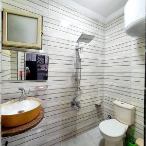 ein Bad mit einem Waschbecken und einem WC sowie einen TV in der Unterkunft Sea view apartment 3 bedrooms 2 toilets 3 air conditioners in Alexandria