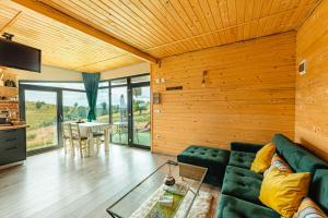 a living room with a green couch and a table at Sweet Escape Vlădeasa in Rogojel