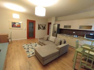 a living room with a couch and a kitchen at Kora Apartaments - Relaxing Escape in Tirana
