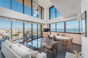 a living room with a couch and a table and chairs at Moderne 3BR - Vue mer in Tel Aviv