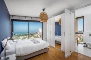 a white bedroom with a view of the ocean at Moderne 3BR - Vue mer in Tel Aviv +24 photos