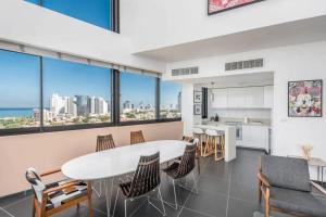 a kitchen and living room with a white table and chairs at Moderne 3BR - Vue mer in Tel Aviv