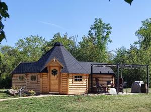a log cabin with a black roof at Le kota des 3 tilleuls in Dampierre-sur-Salon