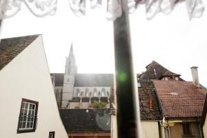 una vista da una finestra di una chiesa con una torre di Hotel Schwarzer Adler a Rothenburg ob der Tauber