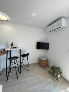 a living room with a table and a tv on a wall at Apartments old town Hvar sea view in Hvar