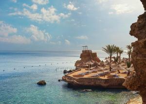 una playa con sillas y sombrillas y el océano en Dreams Vacation Resort - Sharm El Sheikh en Sharm El Sheikh