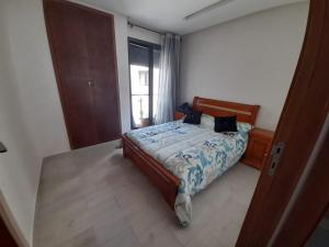 a bedroom with a bed and a window at Appartement plage Mehdia in Plage de Mehdia