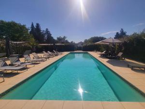 - une piscine avec des chaises longues dans l'établissement Domaine du Prieuré d'Estagel chambres d'hôtes, à Saint-Gilles