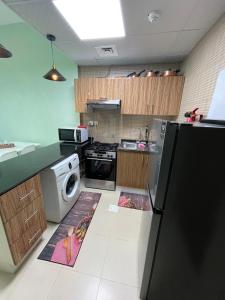 a kitchen with a washer and dryer on the floor at One bedroom new brand in ajman in Ajman 