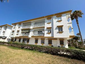 ein weißes Gebäude mit einem Balkon und einer Palme in der Unterkunft Apartamento en Primera Línea de Playa in Torrox