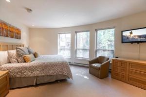 a bedroom with a bed and a tv and a chair at Ski In Ski Out condo with Access to Vail Mountain in Vail