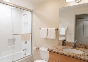 a white bathroom with a sink and a shower at Ski In Ski Out condo with Access to Vail Mountain in Vail +12 photos