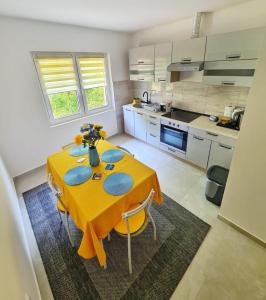 a kitchen with a table with a yellow table cloth at Apartman Berlin Sokobanja in Soko Banja