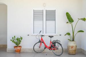 a red bike parked in front of a window at Villa Carlotta con piscina in Noto Marina
