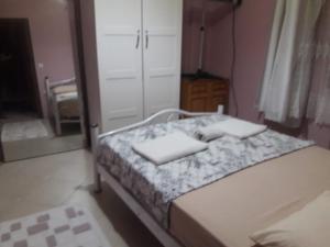 ein Schlafzimmer mit einem Bett mit zwei Kissen und einem Spiegel in der Unterkunft Yenifoça taş ev 1.daire in Foça