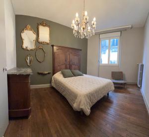 - une chambre avec un lit et un lustre dans l'établissement Chez Rockette, à Verdun-sur-Meuse