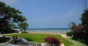 un parc avec une plage et l'océan en arrière-plan dans l'établissement Chelona Hua Hin, à Khao Tao
