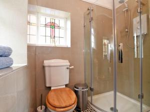 a bathroom with a toilet and a glass shower at Riverbank Cottage in Alnwick +12 photos