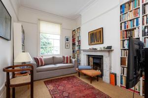 a living room with a couch and a fireplace at Veeve - Eclectic Embrace in London