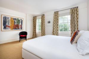 a bedroom with a white bed and a window at Veeve - Eclectic Embrace in London