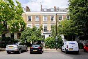 two cars and a van parked in front of a building at Veeve - Eclectic Embrace in London