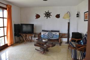 sala de estar con mesa y TV en Brisas del Diablo 3, en Punta del Diablo