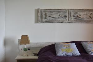 a bed with a wooden headboard and a table with a lamp at Brisas del Diablo 3 in Punta Del Diablo