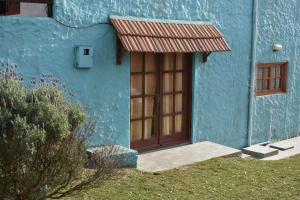 un edificio azul con puerta y ventana en Brisas del Diablo 3, en Punta del Diablo