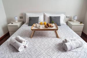 Un dormitorio con una cama con una bandeja de comida. en [DUOMO-Cadorna] Cozy with WiFi & A/C, en Milán