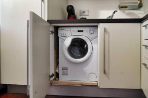 a washing machine in a cabinet in a kitchen at [DUOMO-Cadorna] Cozy with WiFi & A/C in Milan