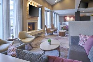 a lobby with couches and chairs and a fireplace at Courtyard by Marriott Detroit Troy in Troy
