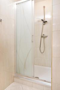 y baño con ducha y puerta de cristal. en Apartament Alicja en Władysławowo