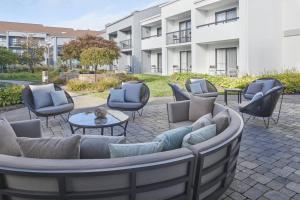 a patio with couches and chairs and a table at Courtyard by Marriott Detroit Troy in Troy