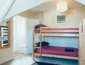 Smarties Surf Lodge في نيوكواي: غرفة بسرير بطابقين مع ثلاثة أسرة في غرفة