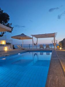 - une piscine avec vue sur l'océan la nuit dans l'établissement Pouletis Family Villas Sea Apartments, à Kalamata