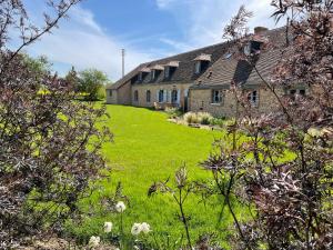 een oud stenen huis met een groen gazon ervoor bij maison de charme à 1h 30 de Paris in Saint-Éman